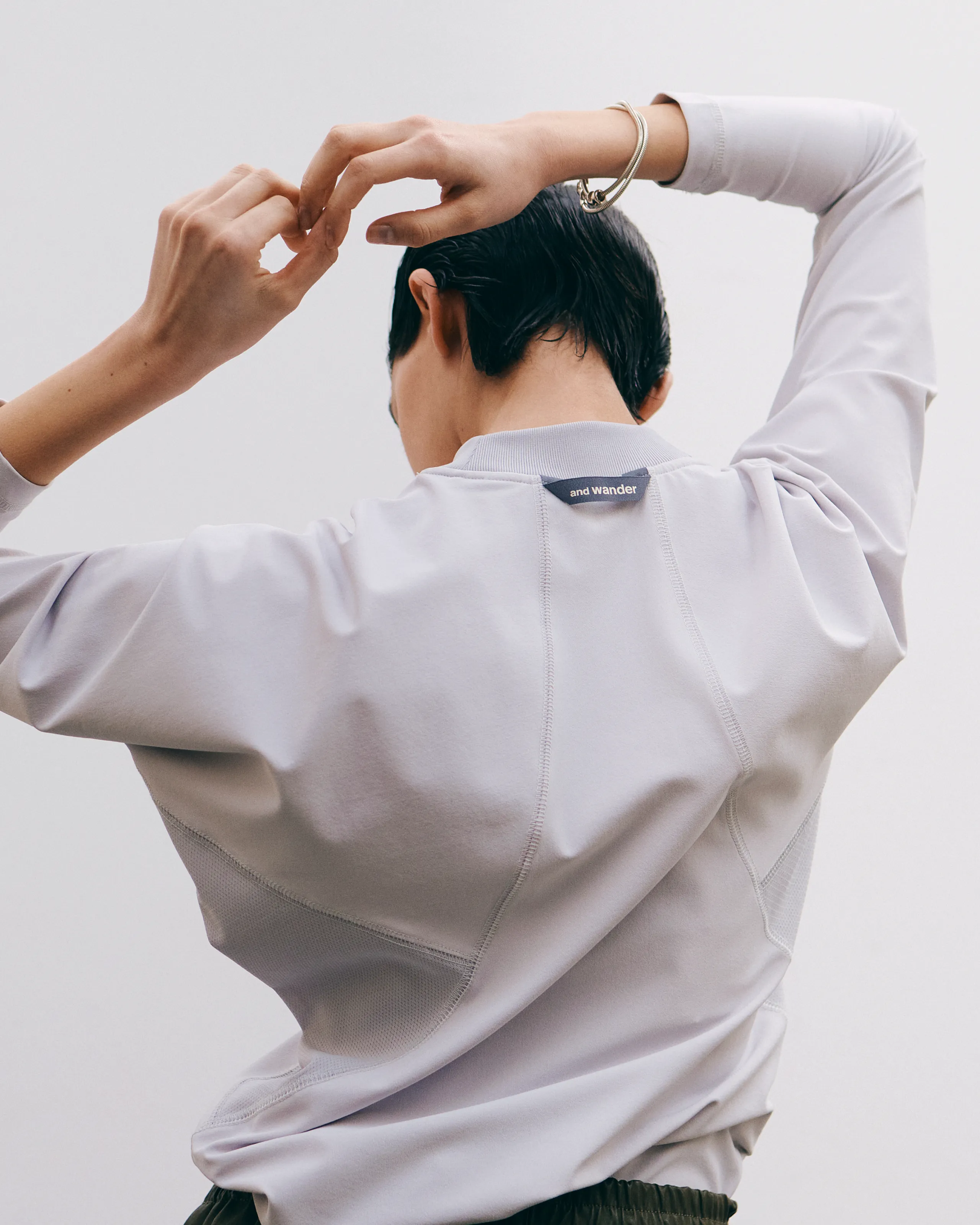 白のトップスとカーキのパンツを履いている女性