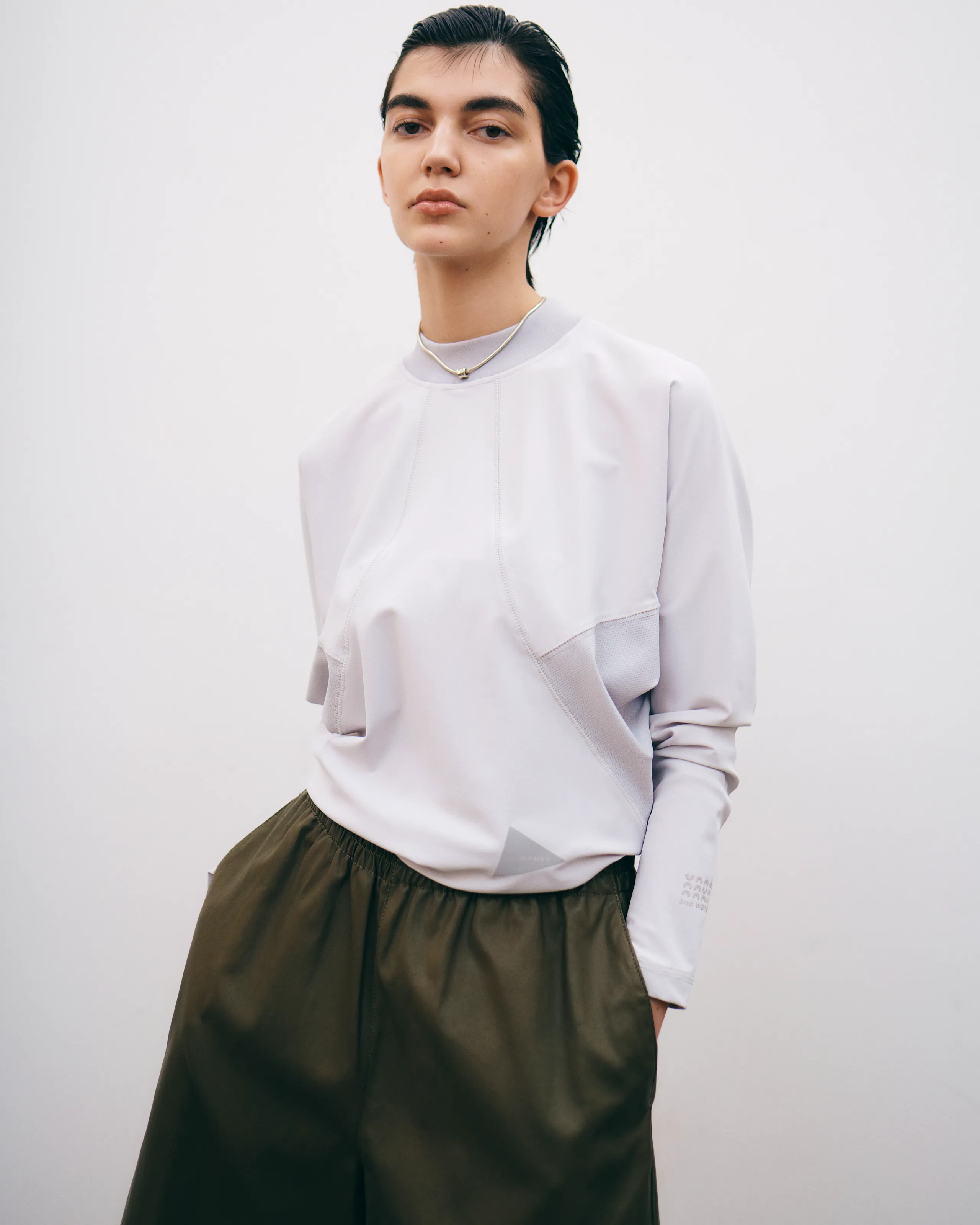 白のトップスとカーキのパンツを履いている女性